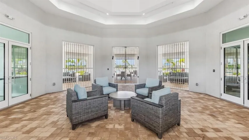 This expansive outdoor space features light-toned floor tiles, white walls, and glass double doors