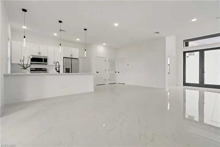 Unfurnished living room featuring sink and french doors