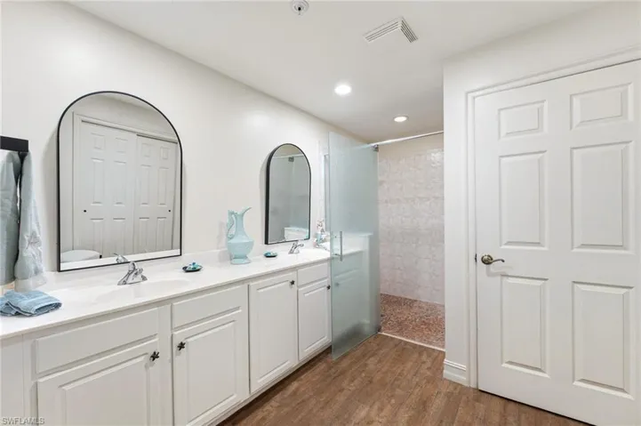 The primary bath offers comfort-height dual vanities, a seamless rain glass shower enclosure, and striking dual mirrors, creating a refined and spa-like retreat. Private water closet.