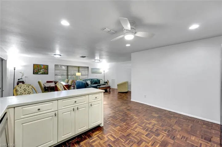 Kitchen with breakfast bar and ceiling fan.