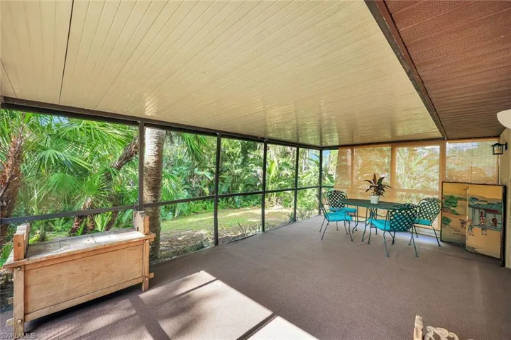 Back lanai with view of yard and stream.