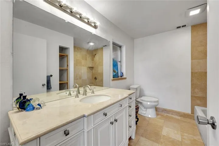 Primary bathroom featuring new vanity and countertop, shower/ tub combo with tiled walls.