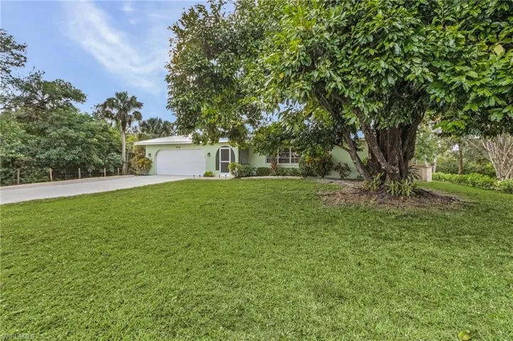 View of front of home with a garage and a front lawn