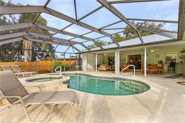 View of pool with a lanai, ceiling fan, a patio area, an outdoor living space, and an in ground hot tub