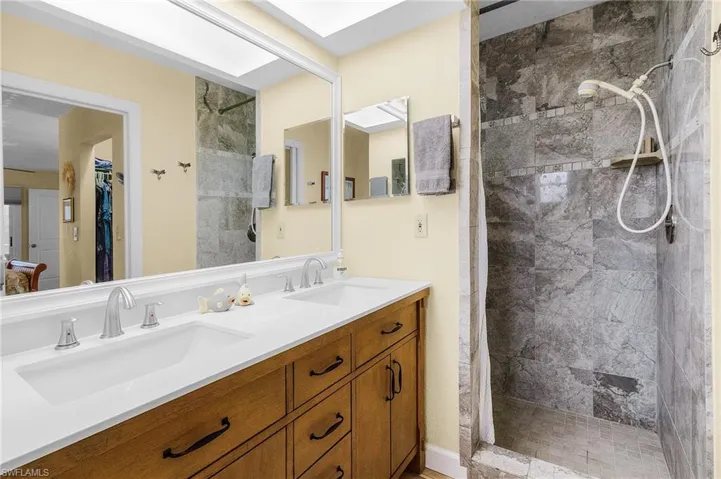 Bathroom featuring vanity and a tile shower