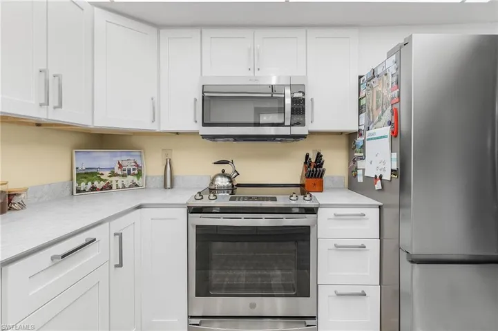 Kitchen with white cabinetry and stainless steel appliances