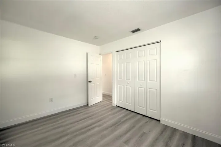 Unfurnished bedroom with wood-type flooring and a closet