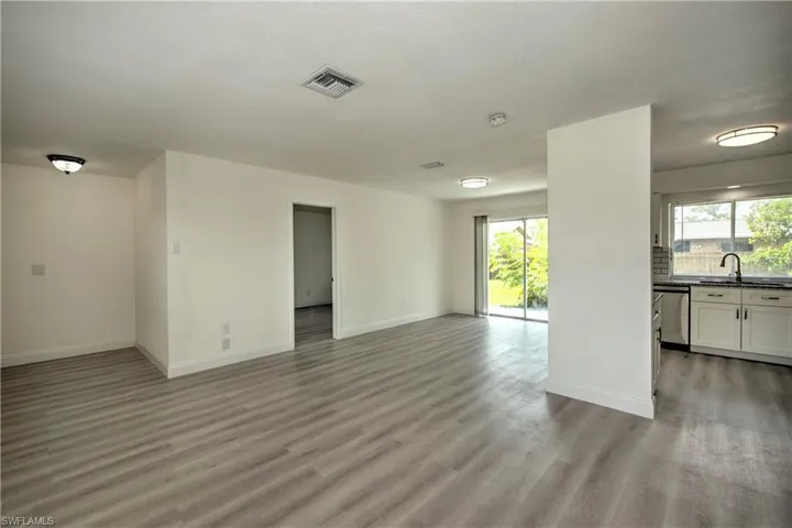 Unfurnished living room with a healthy amount of sunlight, light hardwood / wood-style floors, and sink