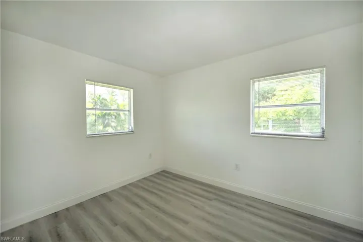 Unfurnished room with plenty of natural light and hardwood / wood-style floors