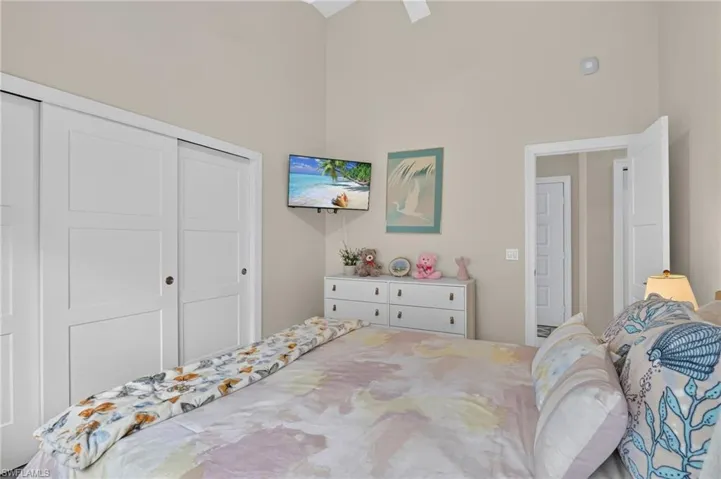Vaulted ceiling with a ceiling fan, white paneled sliding closet doors, and recessed lighting