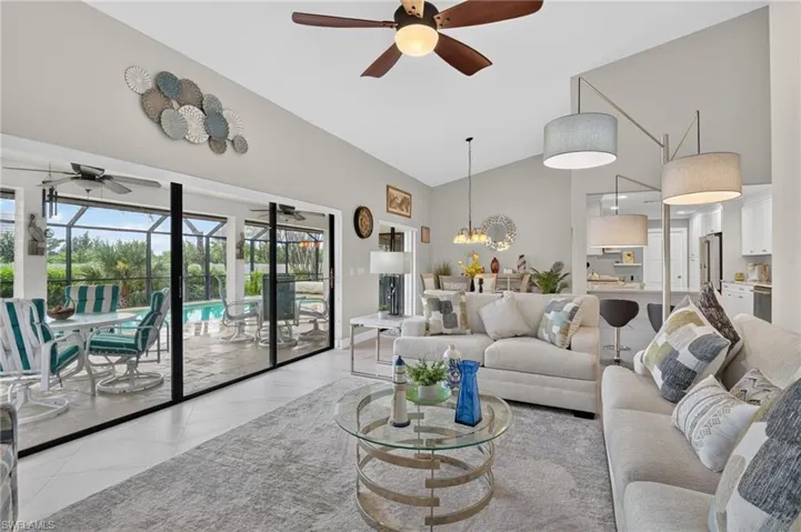 Vaulted ceilings highlight an open living area featuring tile flooring and a ceiling fan