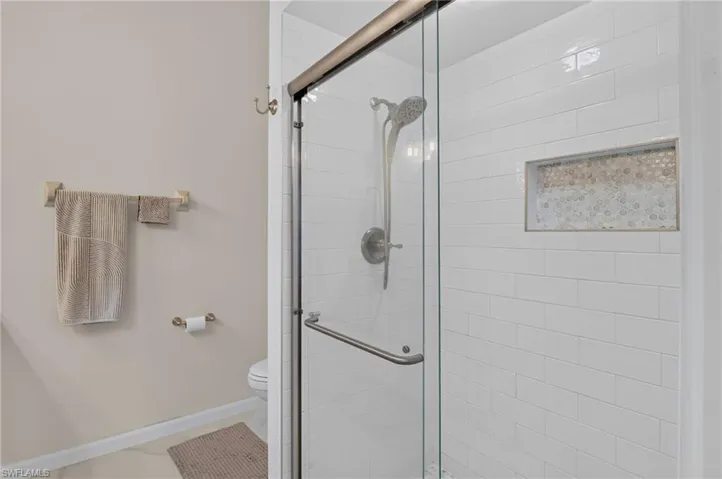 Shower enclosure featuring a glass sliding door and brushed nickel hardware