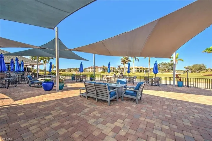 Expansive paver patio with multiple shade sails, offering various seating arrangements