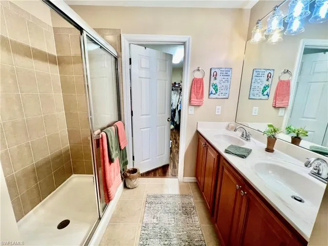 Primary bathroom with dual sinks and walk in shower.
