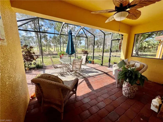 Screened Lanai with a  wealth of natural light, outdoor dining space, and ceiling fan