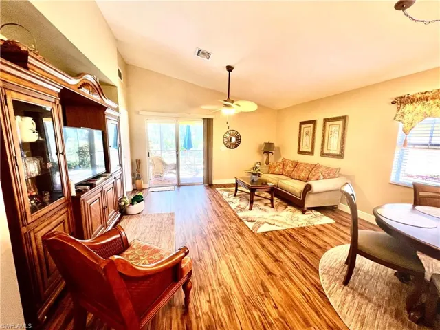 Living room with ceiling fan, wood finished floors, and plenty of natural light