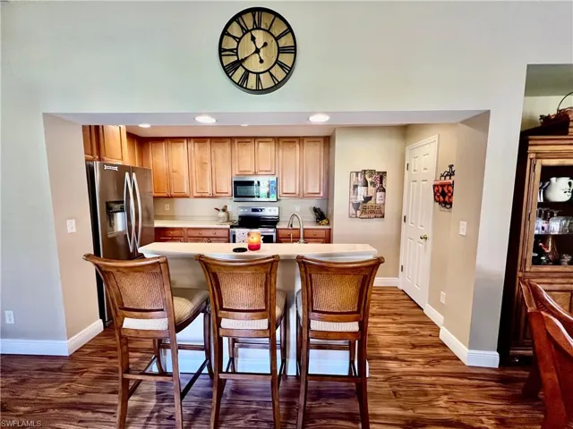 Kitchen featuring wood-type flooring, baseboards, and appliances with stainless steel finishes