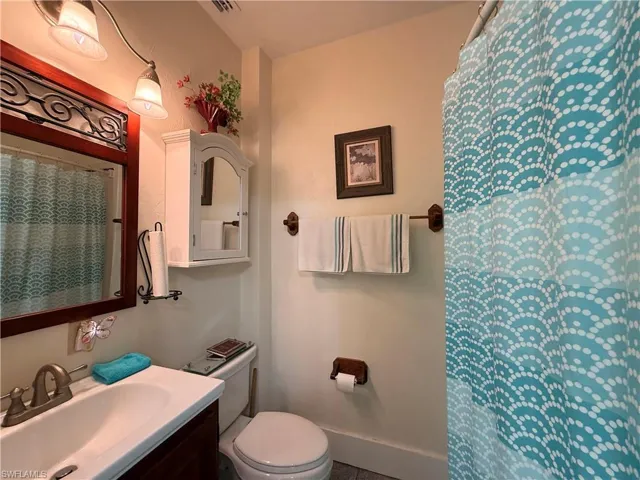 Full bath with a shower with shower curtain and vanity