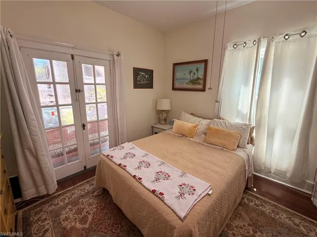 Bedroom featuring access to exterior, french doors, and dark heart pine floors