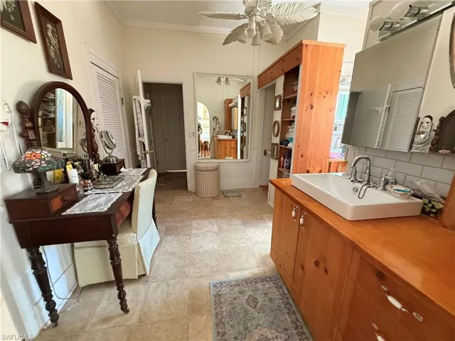 Full bathroom featuring vanity, ornamental molding, ceiling fan, and tasteful backsplash