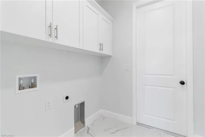 Laundry room featuring marble look tile flooring, washer hookup, hookup for an electric dryer, and cabinet space