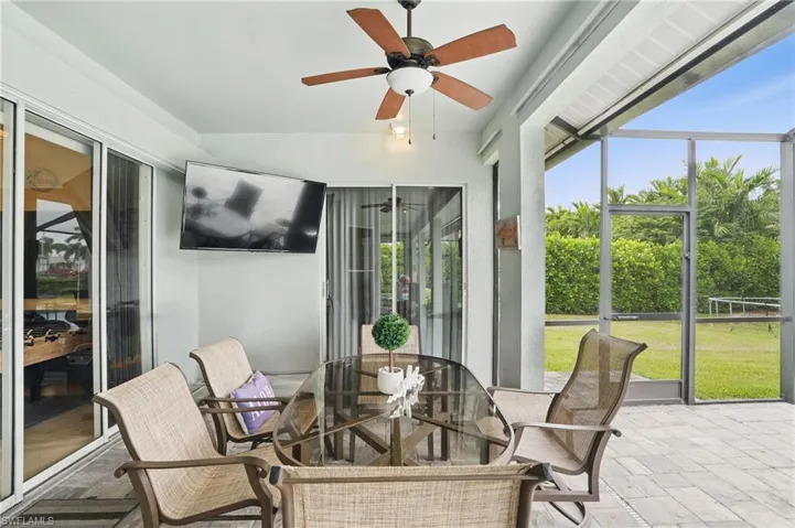 Sunroom / solarium with ceiling fan, plenty of natural light, and outdoor dining area
