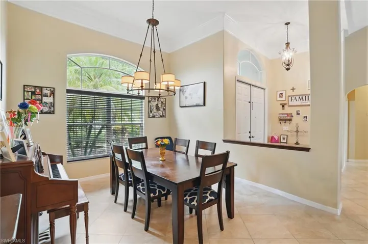 Dining space with a chandelier, crown molding, and light tile patterned floors