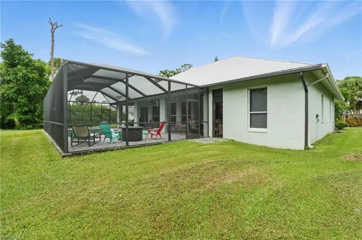 Rear view of property with a patio, stucco siding, a lawn, and ceiling fan