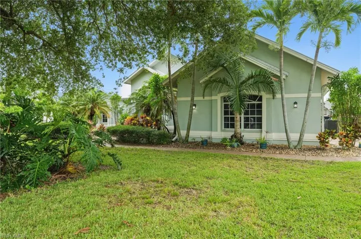 View of side of home with a yard and stucco siding