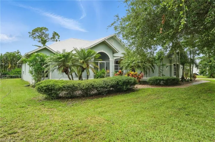 View of front facade with stucco siding and a front yard