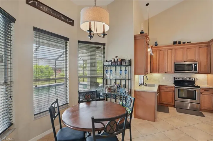 Kitchen with appliances with stainless steel finishes, a sink, light countertops, tasteful backsplash, and light tile patterned flooring
