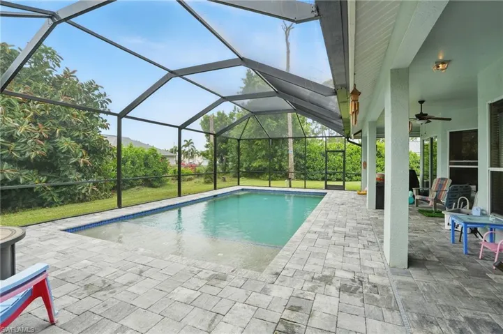 Outdoor pool with a ceiling fan, a patio, and glass enclosure