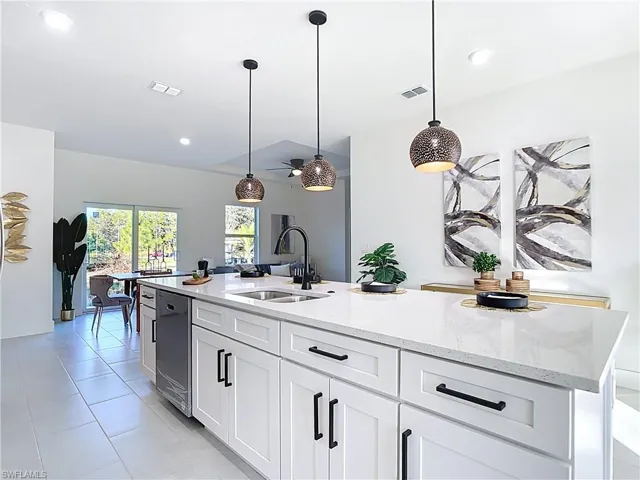 Kitchen island featuring white shaker cabinetry, matte black hardware, and a light-toned countertop