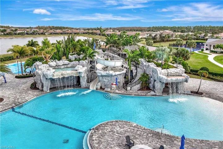 Community pool featuring a water slide and a water view