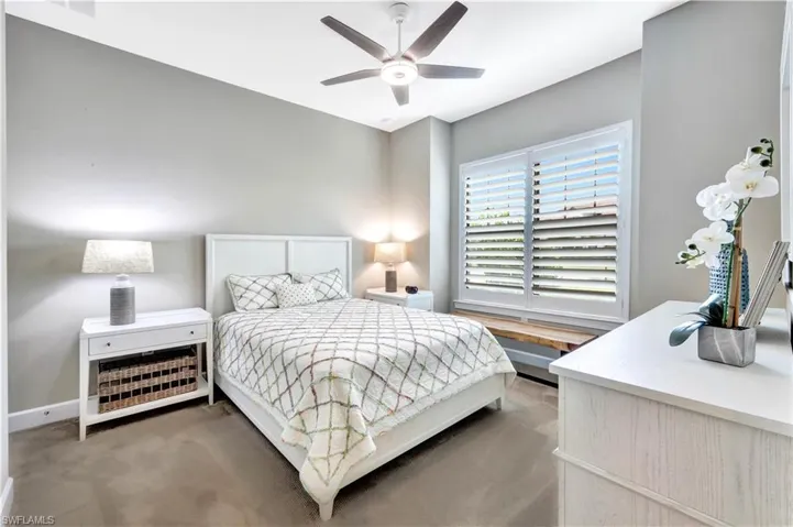 Bedroom featuring baseboards, dark carpet, and a ceiling fan