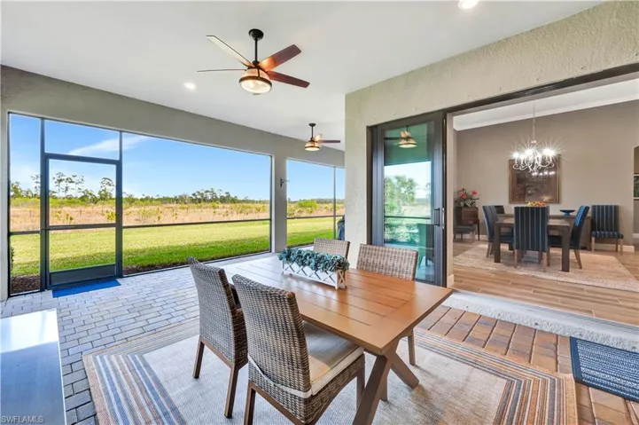 Sunroom with ceiling fan with notable chandelier