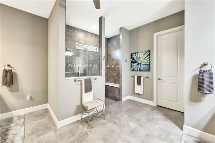 Full bath with a walk in shower and baseboards