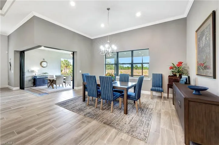 Dining room with wood tiled floor, a notable chandelier, and baseboards