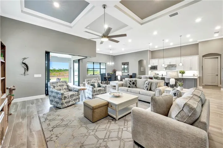 Living room featuring light wood finished floors, visible vents, and arched walkways