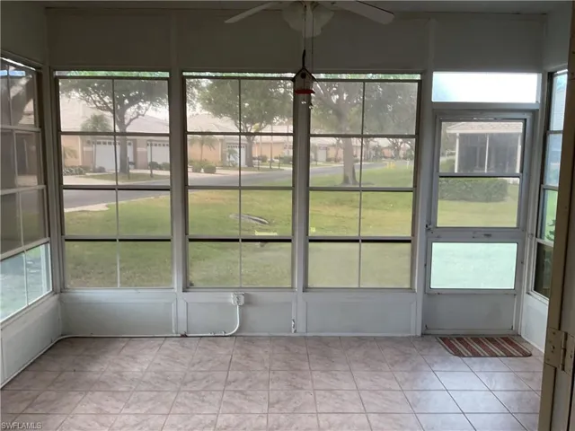 Unfurnished sunroom with a wealth of natural light and ceiling fan