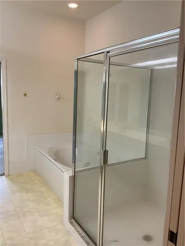 Full bathroom featuring a bath, tile patterned floors, and a stall shower