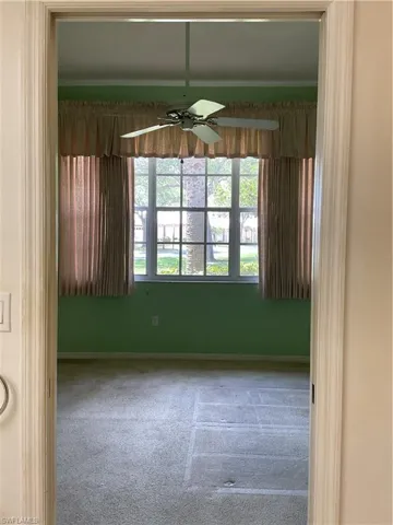 Empty room with baseboards, a ceiling fan, and carpet