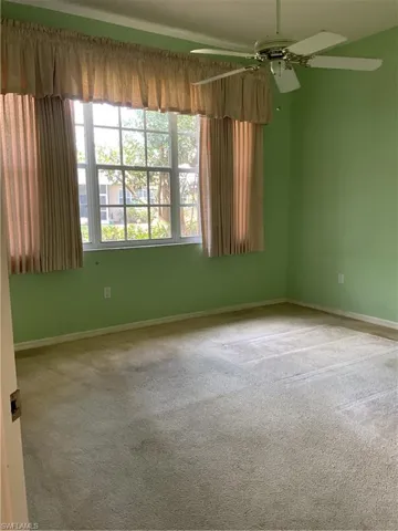 Spare room featuring carpet flooring, baseboards, and a ceiling fan