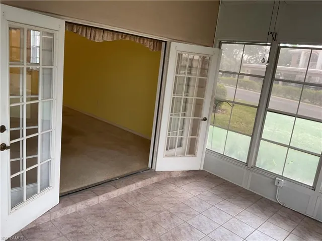 Unfurnished sunroom with french doors