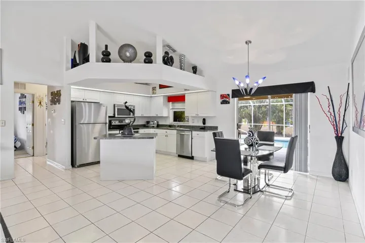 Bright kitchen featuring stainless appliances and open flow to dining area.