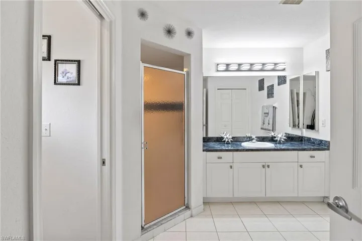 Primary bathroom featuring a spacious walk-in shower.