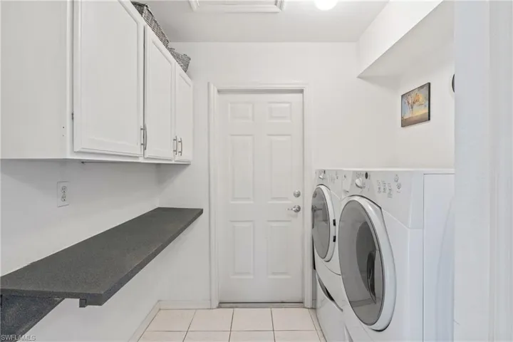 Clean, organized laundry room with ample workspace and storage.