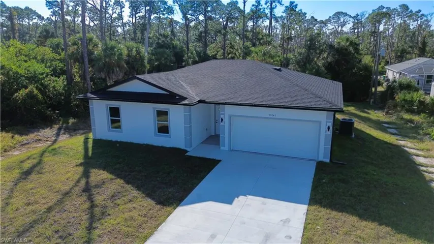 Single story home featuring a front lawn, driveway, a garage, and stucco siding