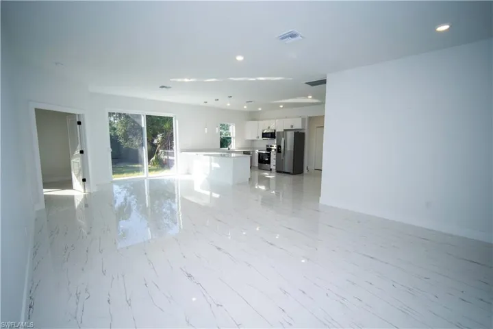 Unfurnished living room featuring recessed lighting and light marble finish flooring