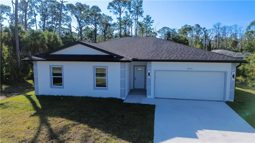 Ranch-style house featuring a shingled roof, driveway, a front lawn, a garage, and stucco siding